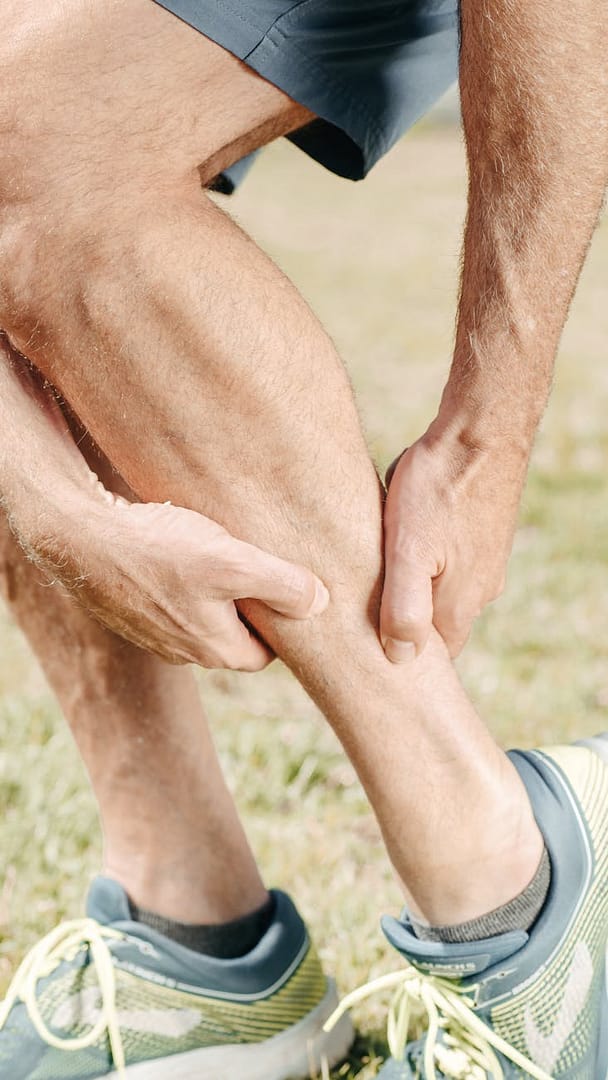 man massaging his calf muscles